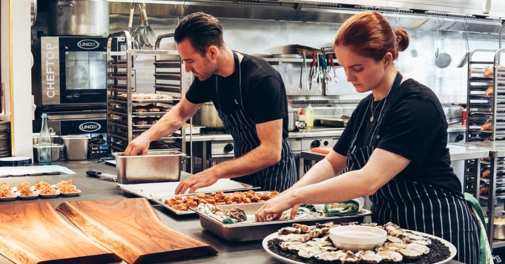 Two chefs working in appropriate kitchen workwear.