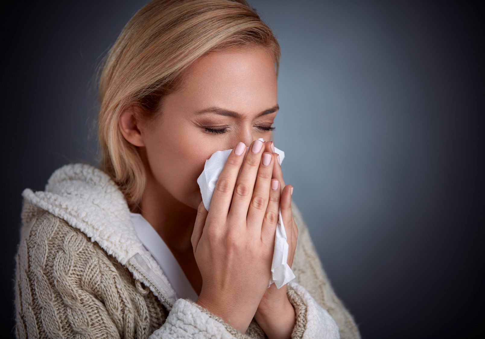 woman having flu, feeling bad and blowing her nose