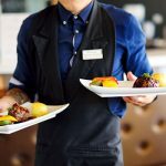 man holding two plates dinners